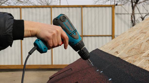 istock attaching soft tiles to a wooden roof using a screwdriver 2173328936