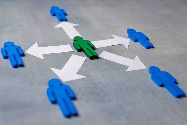 A green figure at the center surrounded by blue figures with arrows. A green figure at the center surrounded by blue figures with arrows. Delegation concept. Green figure distributes tasks or responsibilities to others. delegating stock pictures, royalty-free photos & images