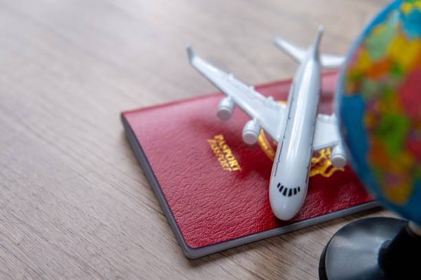 istock A small model airplane on top of a passport and next to a small globe. 2173329099