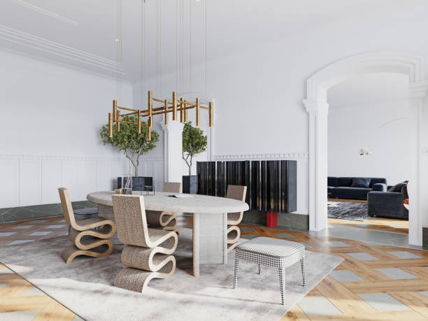 istock Luxurious dining room with modern sculptural chairs, a round stone table, and a brass chandelier, accented by natural light and greenery. 2173330304
