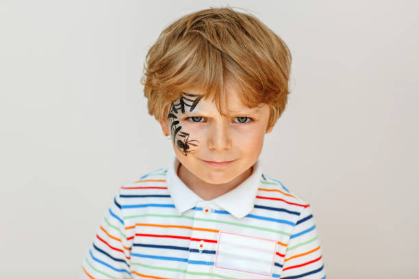 istock little kid boy with face painted with a spider web, Activity for kids on birthday celebration part, face painting, fun and happiness 2173331727