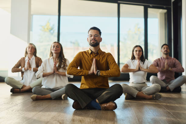 istock Young colleagues meditating on the floor in the office. 2173337463
