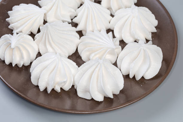 Meringue or suspiro sweet  dessert over pink color background . High angle view  and copy space to left side of the image for any text