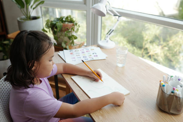 istock Girl Studying At Table At Home 2173344706