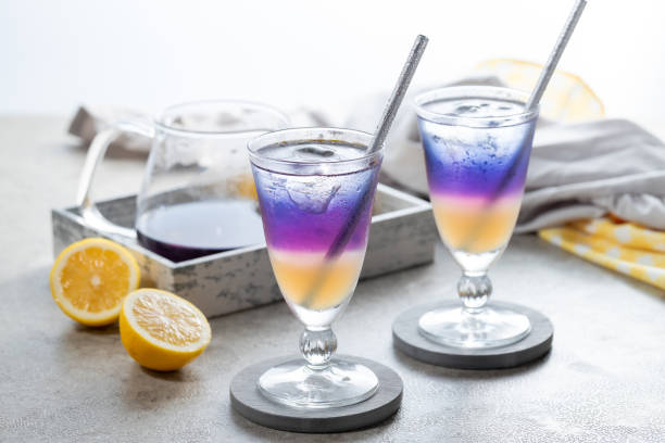 istock Lemonade with blue and violet butterfly pea flower tea on light gray background with copy space 2173344731