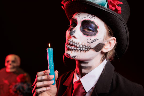 istock Lady lighting candle at religious processions during Dia de los Muertos 2173350118
