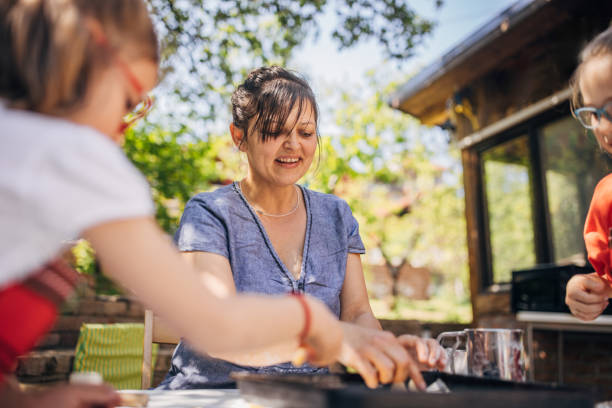 istock Happy supervisor assists children in baking project. 2173354337