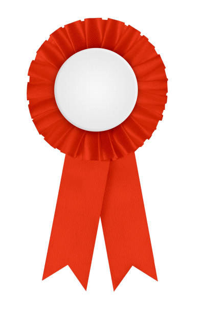 Red winners prize rosette. Circular pleated first place award with blank white center for applying a design to. Photographed isolated on a blank white background.