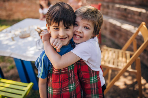 Close-up of two smiling boys enjoying time together on a couch.Close-up of two smiling boys enjoying time together on a couch.