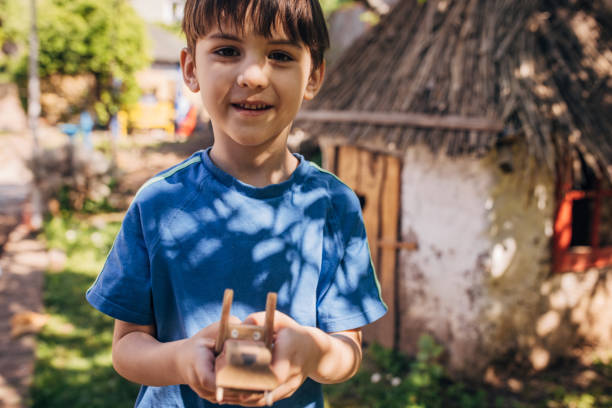 istock Boy holding toy wolf in a sunny backyard garden. 2173362038