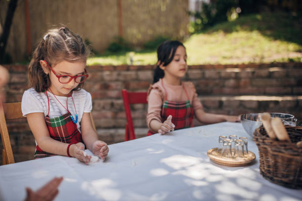 istock Two children baking at outdoor table with white cloth 2173364885