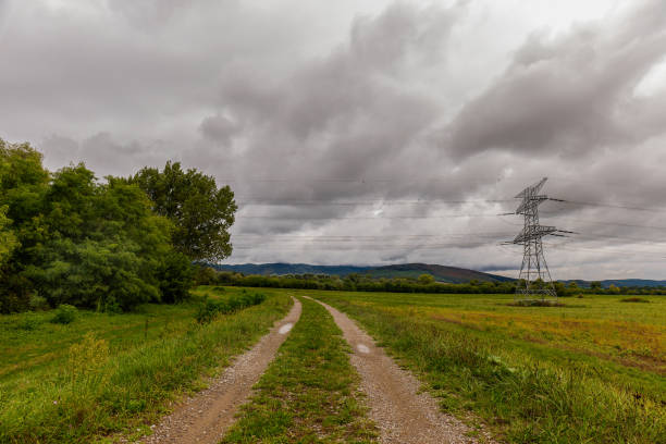 istock High voltage overhead power line. Green meadow with a cloudy stormy sky 2173366149