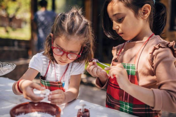 istock Young girls decorating cookies with jam and sugar 2173368715