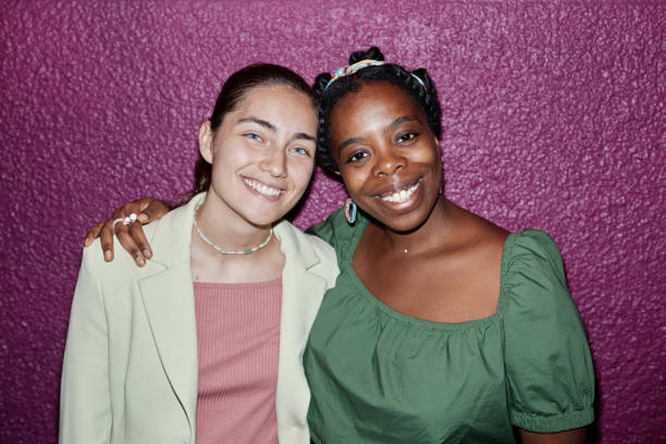 High angle portrait of biracial friends smiling widely and looking at camera