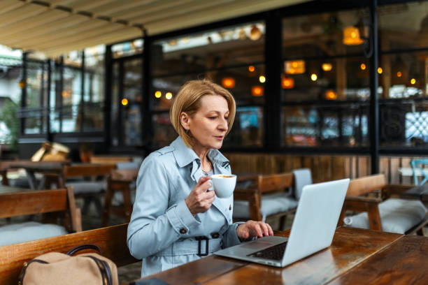 istock Senior businesswoman using laptop in a cafe 2173372261
