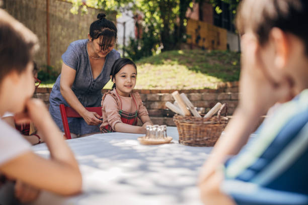 istock Children sitting outdoors with aprons in green area 2173373015