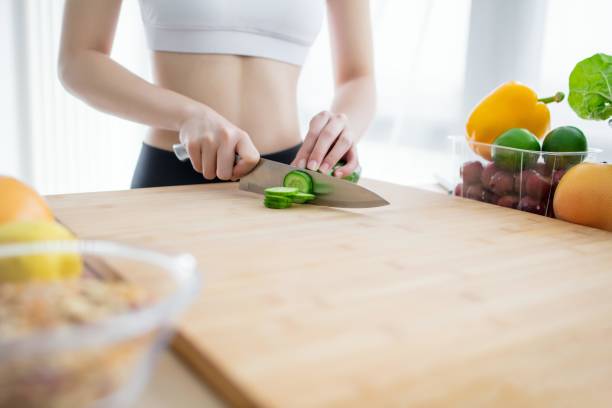istock A woman cutting cucumber in the kitchen 2173375555