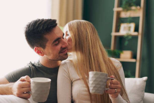 istock Beautiful young happy couple enjoying coffee at home on sofa 2173377761