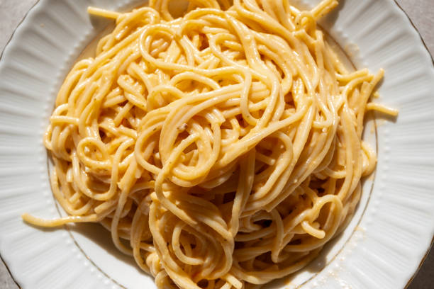 creamy spaghetti pasta on white plate in close-up slow motion