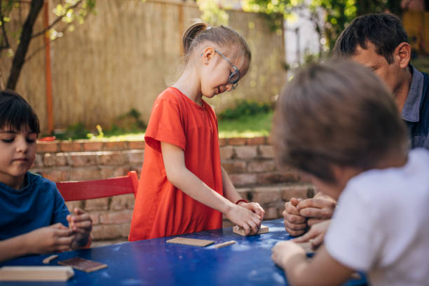 istock Girl stands while kids focus on creative activities. 2173379028