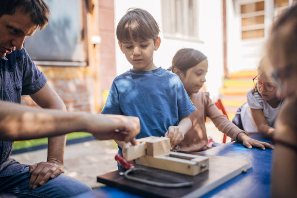 istock Child learning woodworking outdoors with guidance. 2173381584