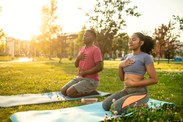 istock Young couple practicing yoga in a summer park, doing breathing exercise 2173382926
