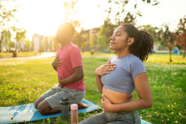 istock Young couple practicing yoga in a summer park, doing breathing exercise 2173382947