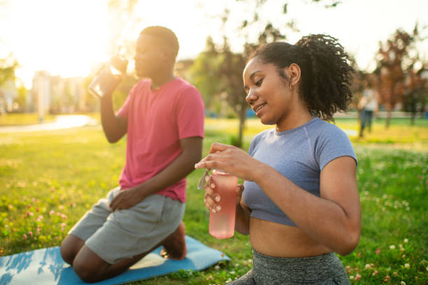 istock Young couple practicing yoga in a summer park 2173382952