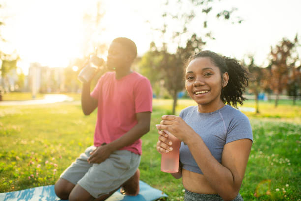 istock Young couple practicing yoga in a summer park 2173382987