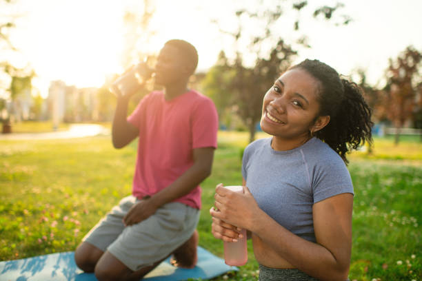 istock Young couple practicing yoga in a summer park 2173382988