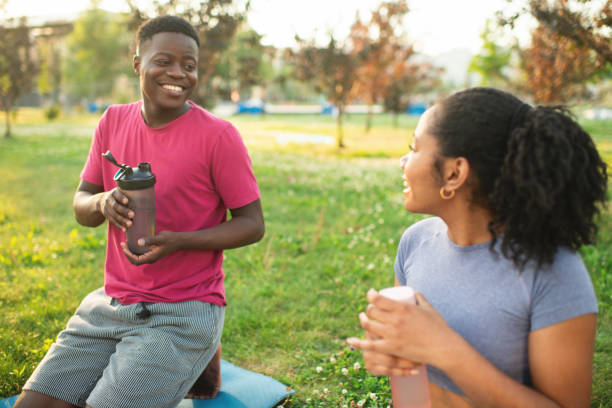 istock Young couple practicing yoga in a summer park 2173382999