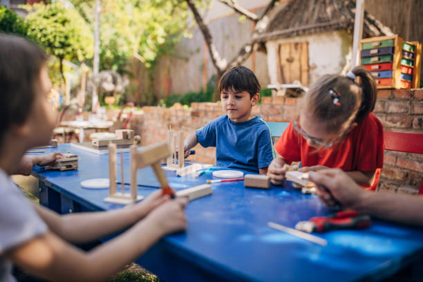 istock Children building wood projects in sunny outdoor setting 2173387268