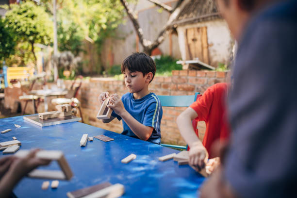 istock Children building wooden structures at a blue table 2173387521