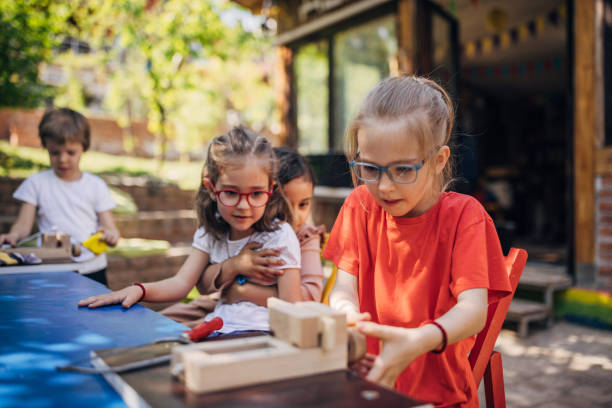 istock Children exploring woodworking skills with adult help. 2173394814