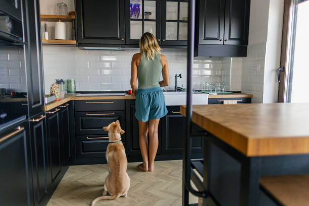 istock Woman and her dog in the kitchen 2173396005