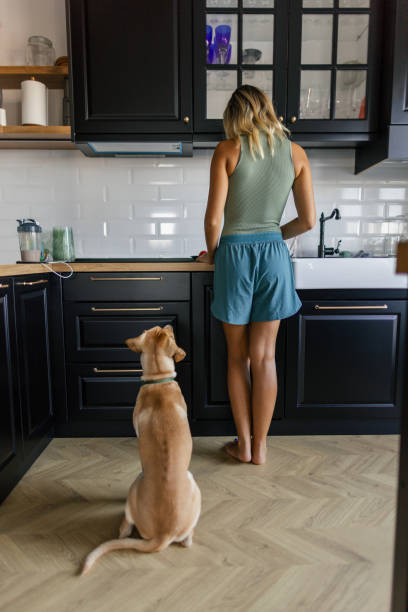 istock Woman and her dog in the kitchen 2173396025