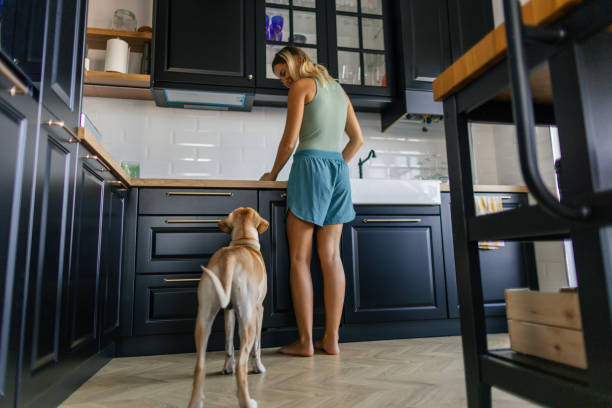 istock Woman and her dog in the kitchen 2173396030