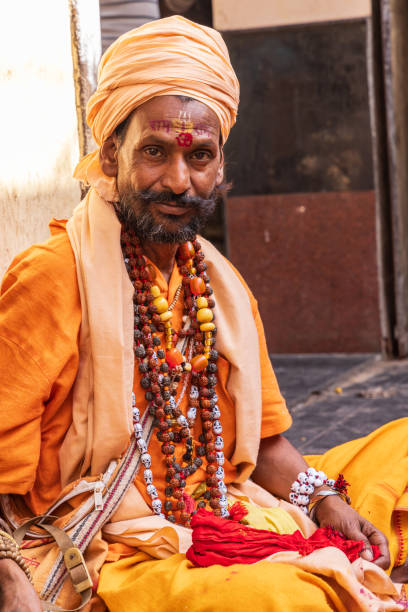Pushkar, Rajasthan, India. November 7, 2022. Sadhu wearing beads on a sidewalk in Pushkar.