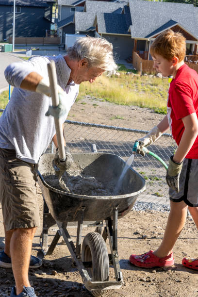 istock Grandfather and grandson build rock patio together 2173396708