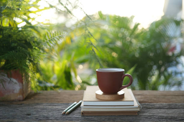 istock tea cup and notebook and pencil on wooden table under sunlight 2173397452
