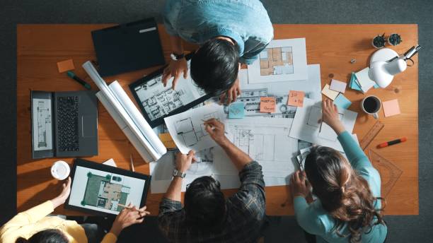 istock Top view of engineer team holding blueprint and standing at table. Symposium. 2173399625