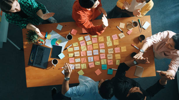 istock Top down view of business people writing marketing idea at meeting. Convocation. 2173402425
