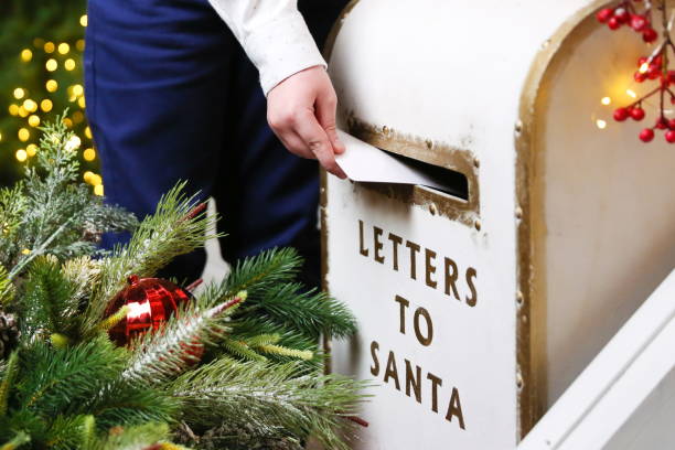 istock a child's hand drops a letter into Santa Claus's mailbox 2173407860