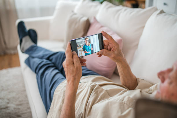 istock A senior man talks to a nurse via video call while lying on a comfortable sofa in the living room 2173409072