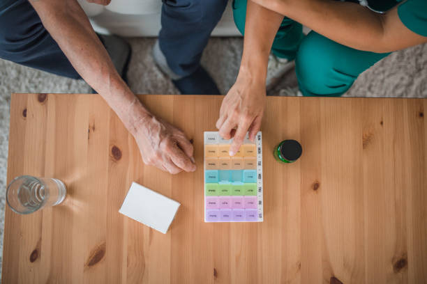 istock An unrecognizable nurse sits next to a senior patient helping him arrange supplements in a plastic pill box 2173409380