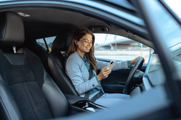 istock Businesswoman using smartphone while driving in modern car 2173410346