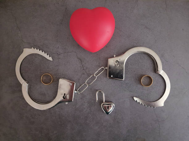 istock Gold wedding ring, heart-shaped padlock, and handcuffs. 2173410442