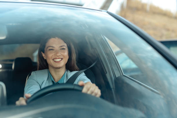 istock Beautiful woman smiling while confidently driving a car 2173410557