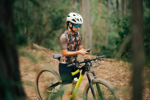 istock Woman on her bike using cell phone 2173411677