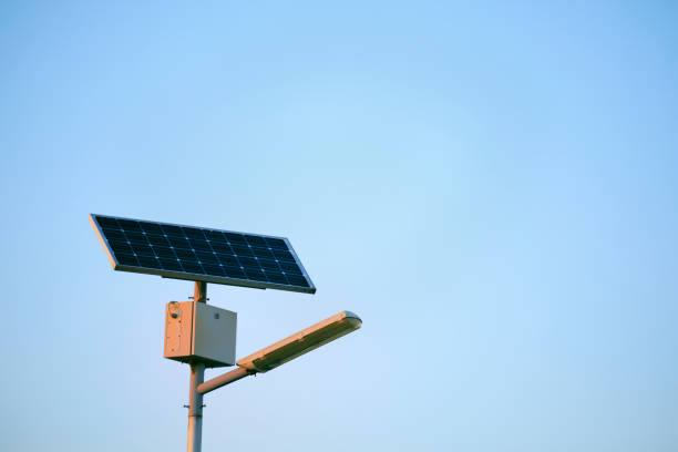 Street lamp posts with solar powered energy panel against a clear blue sky background.